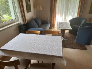 ein Wohnzimmer mit einem Tisch, Stühlen und einem Sofa in der Unterkunft Beautiful apartment in Gortipohl with garden in Gortipohl