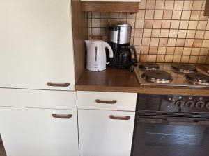 eine Küche mit weißen Schränken und einer Kaffeemaschine in der Unterkunft Beautiful apartment in Gortipohl with garden in Gortipohl