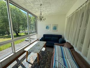 ein Wohnzimmer mit einem Sofa, einem Tisch und Fenstern in der Unterkunft Beautiful apartment in Gortipohl with garden in Gortipohl