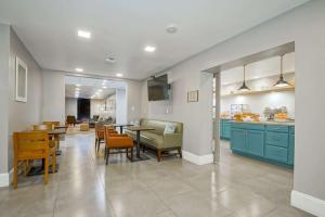 紐奧良的住宿－Country Inn & Suites by Radisson, New Orleans I-10 East, LA，厨房以及带蓝色橱柜和椅子的用餐室。