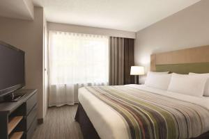 Un pat sau paturi într-o cameră la Country Inn & Suites by Radisson, Washington, D.C. East - Capitol Heights, MD