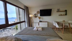 a bedroom with a bed with a view of the ocean at Nova Patagonia Apart Bariloche in San Carlos de Bariloche