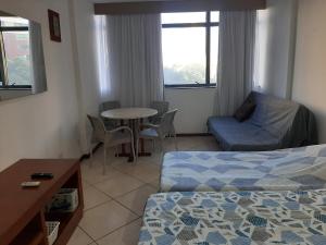 Cette chambre comprend un lit, une table et un canapé. dans l'établissement Flat no Sol Vitória Marina 2, à Salvador