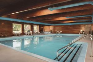 uma grande piscina com mesas e cadeiras em Country Inn & Suites by Radisson, Traverse City, MI em Traverse City