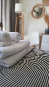 a pile of towels sitting on top of a bed at Nova Patagonia Apart Bariloche in San Carlos de Bariloche