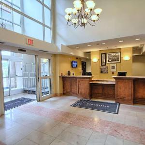 a large lobby with a reception desk and a chandelier at Country Inn & Suites by Radisson, Dearborn, MI in Dearborn