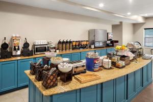 eine Küche mit blauen Schränken und Speisen auf der Theke in der Unterkunft Country Inn & Suites by Radisson, Baltimore North, MD in White Marsh