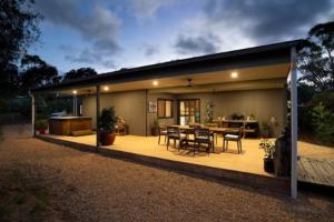 a house with a patio with a table and chairs at The Olive Farm in Clare