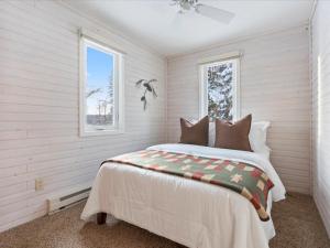 een slaapkamer met een bed en 2 ramen bij Eagles Rest On Whitefish in Pine River