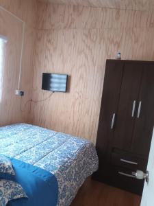 Un dormitorio con una cama, una cómoda y un armario. en Cabaña Balmaceda - Puerto Montt, en Puerto Montt