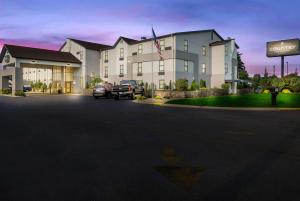 een groot gebouw met auto's geparkeerd voor het bij Country Inn & Suites by Radisson, Grandville-Grand Rapids West, MI in Grandville