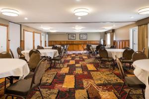 una sala de conferencias con mesas y sillas. en Country Inn & Suites by Radisson, Grandville-Grand Rapids West, MI en Grandville