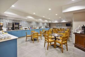 un comedor con mesas y sillas en un restaurante en Country Inn & Suites by Radisson, Big Rapids, MI, en Big Rapids