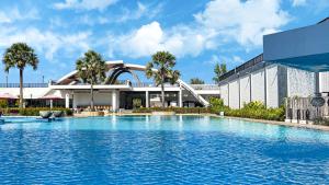 暹粒Pacific Hotel & Spa的建筑物前有一个大型游泳池。