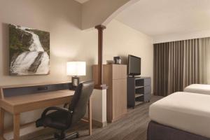 a hotel room with a desk and a bed at Country Inn & Suites by Radisson, Eagan, MN in Eagan