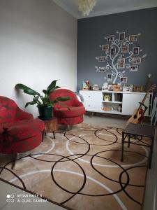 a living room with two chairs and a tree wall at Sobrado aconchegante. in Cascavel