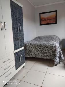 a bedroom with a bed and a dresser in a room at Sobrado aconchegante. in Cascavel
