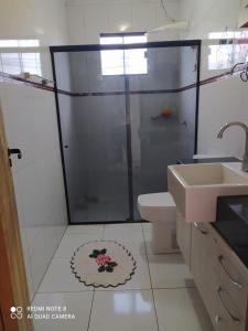 a bathroom with a shower and a toilet and a sink at Sobrado aconchegante. in Cascavel