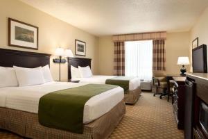 um quarto de hotel com duas camas e uma televisão em Country Inn & Suites by Radisson, Chanhassen, MN em Chanhassen