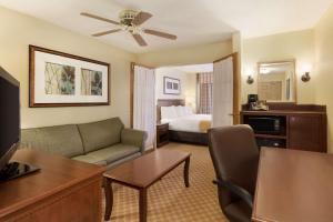 a hotel room with a bed and a living room at Country Inn & Suites by Radisson, Rochester, MN in Rochester