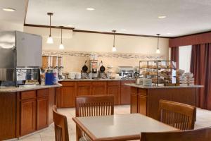 a large kitchen with wooden cabinets and a table and chairs at Country Inn & Suites by Radisson, Coon Rapids, MN in Coon Rapids