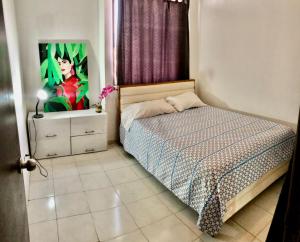 a bedroom with a bed and a painting on the wall at Habitación amoblada con servicios Rio mar in Barranquilla