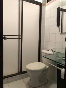 a bathroom with a toilet and a glass sink at Habitación amoblada con servicios Rio mar in Barranquilla