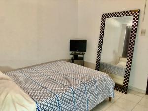 a bedroom with a bed and a mirror at Habitación amoblada con servicios Rio mar in Barranquilla