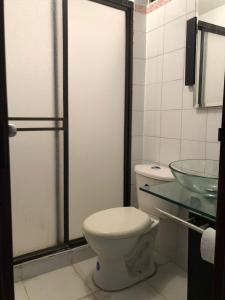 a bathroom with a toilet and a glass sink at Habitación amoblada con servicios Rio mar in Barranquilla