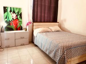 a bedroom with a bed and a painting on the wall at Habitación amoblada con servicios Rio mar in Barranquilla