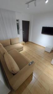 a living room with a couch in the middle at Apartamento Aconchegante Centro Serra Negra in Serra Negra