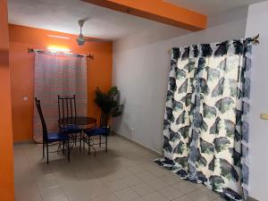 ein Esszimmer mit einem Tisch, Stühlen und einem Fenster in der Unterkunft Ouedraogo Property Management in Ouagadougou