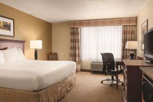 a hotel room with a bed and a desk and a television at Country Inn & Suites by Radisson, Mankato Hotel and Conference Center, MN in Mankato
