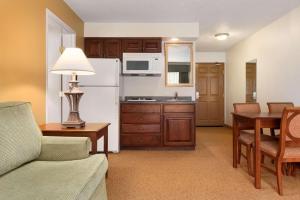 a living room with a couch and a kitchen at Country Inn & Suites by Radisson, Mankato Hotel and Conference Center, MN in Mankato
