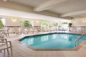 a pool in a hotel with chairs and tables at Country Inn & Suites by Radisson, Mankato Hotel and Conference Center, MN in Mankato