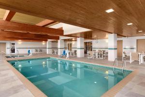 a large swimming pool in a hotel with tables and chairs at Country Inn & Suites by Radisson, Rochester South, MN in Rochester