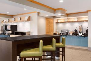 a kitchen with a large island with green bar stools at Country Inn & Suites by Radisson, Rochester South, MN in Rochester