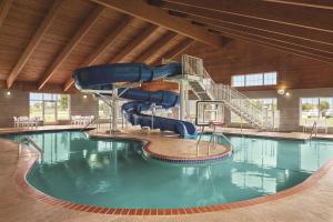a pool with a water slide in a building at Country Inn & Suites by Radisson, Willmar, MN in Willmar