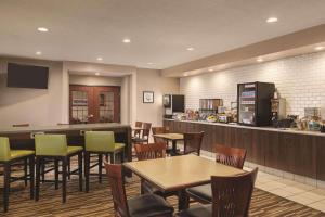a restaurant with tables and chairs and a bar at Country Inn & Suites by Radisson, Willmar, MN in Willmar