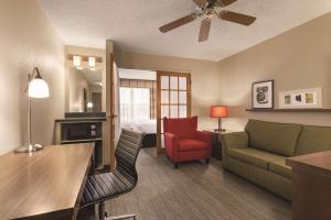 a living room with a couch and a room with a bed at Country Inn & Suites by Radisson, Forest Lake, MN in Forest Lake