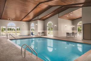 une grande piscine intérieure d'eau bleue dans un bâtiment dans l'établissement Country Inn & Suites by Radisson, Cottage Grove, MN, à Cottage Grove
