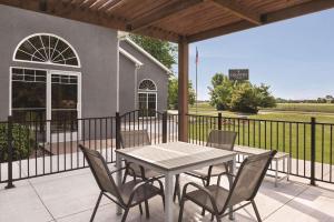 een tafel en stoelen op een patio met een hek bij Country Inn & Suites by Radisson, Cottage Grove, MN in Cottage Grove