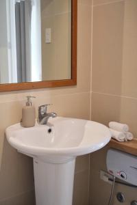 een badkamer met een witte wastafel en een spiegel bij Aginana Villas in san juan la union