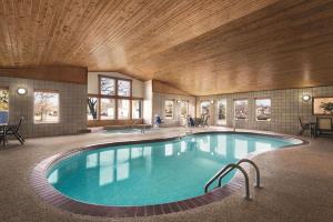 Country Inn & Suites by Radisson, Northfield, MN في نورثفيلد: مسبح كبير في مبنى بسقف خشبي
