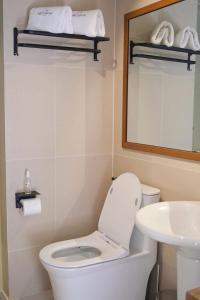 bagno con servizi igienici, lavandino e specchio di Aginana Villas a san juan la union