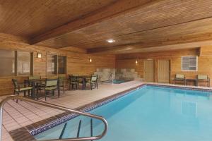 a swimming pool with tables and chairs in a building at Country Inn & Suites by Radisson, Albert Lea, MN in Albert Lea