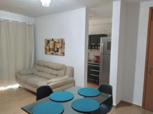 uma sala de estar com um sofá e uma mesa em Apartamento 3/4, 1 suíte Vog Atlântico em Ilhéus