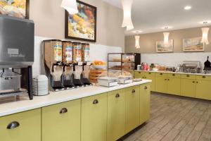 a kitchen with yellow cabinets and a counter with food at Country Inn & Suites by Radisson, Duluth North, MN in Duluth