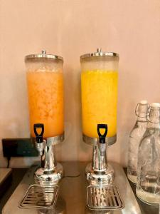 two glasses of orange juice sitting on top of a counter at King Park Hotel Kota Kinabalu in Kota Kinabalu