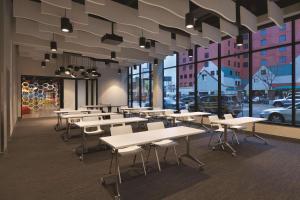 a cafeteria with tables and chairs and windows at Radisson Red Minneapolis Downtown in Minneapolis